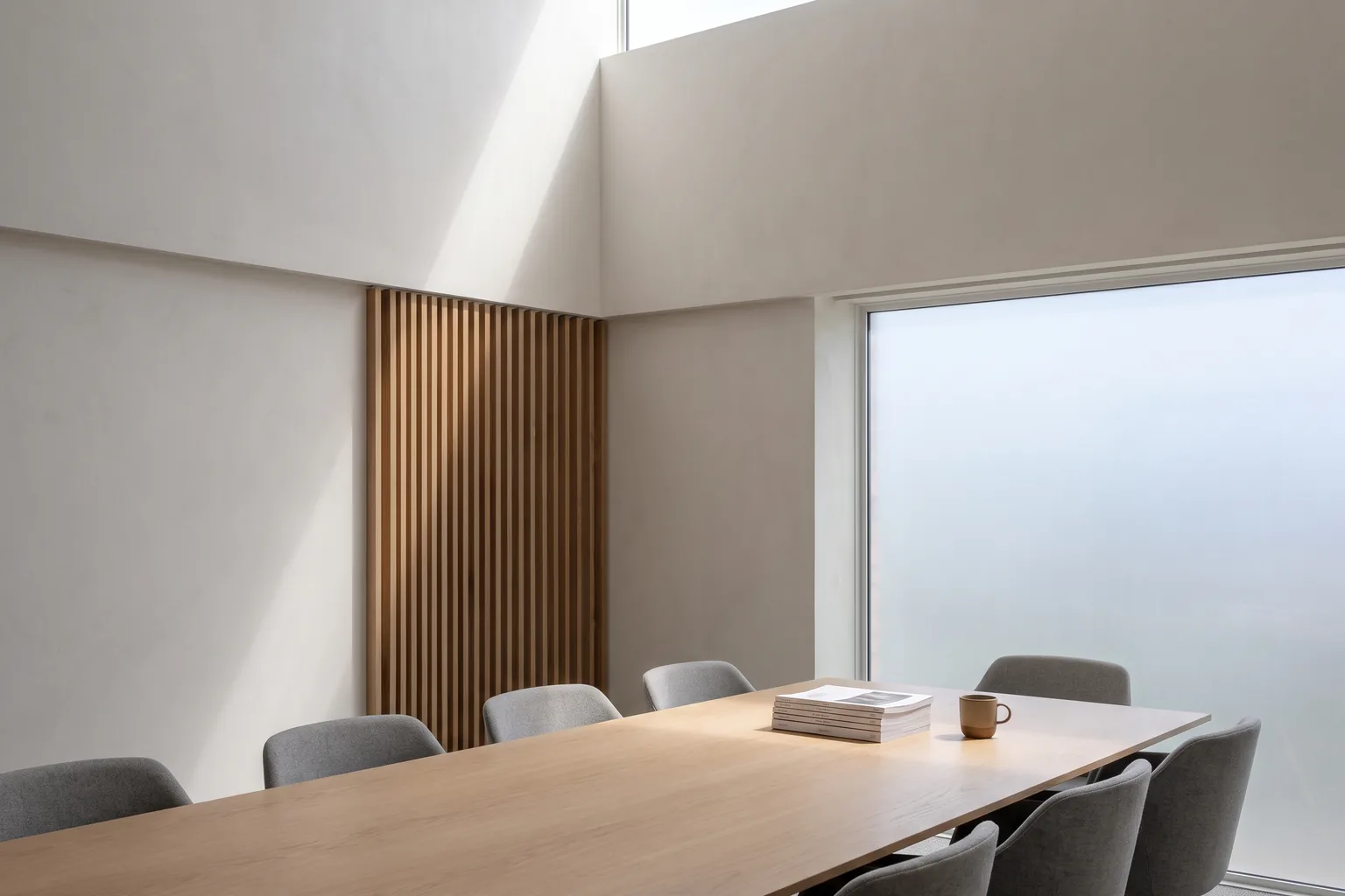 A low-key boardroom with a single shaft of light, the city skyline at night